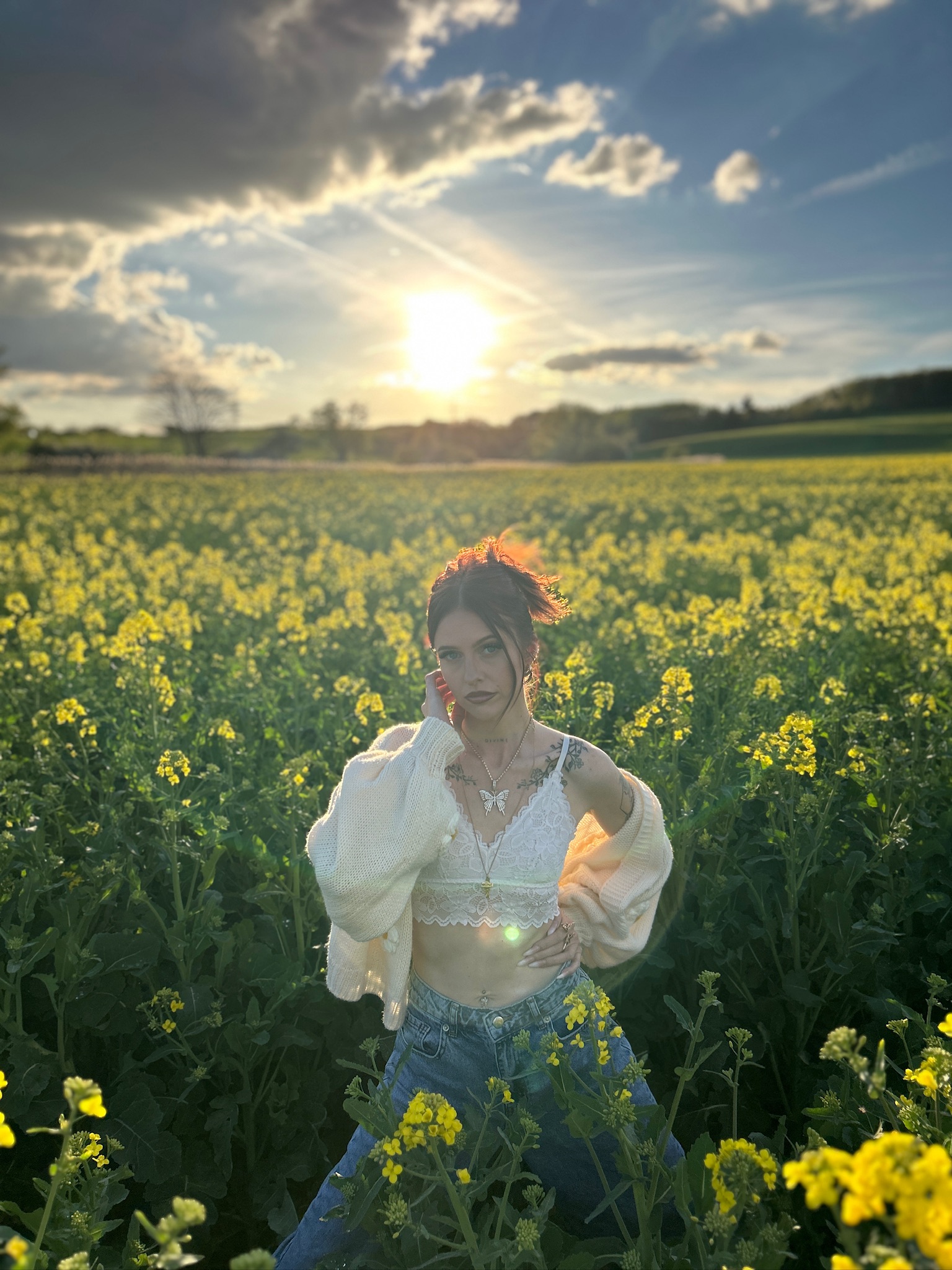 Jess standing in a flower field, looking directly into the camera.