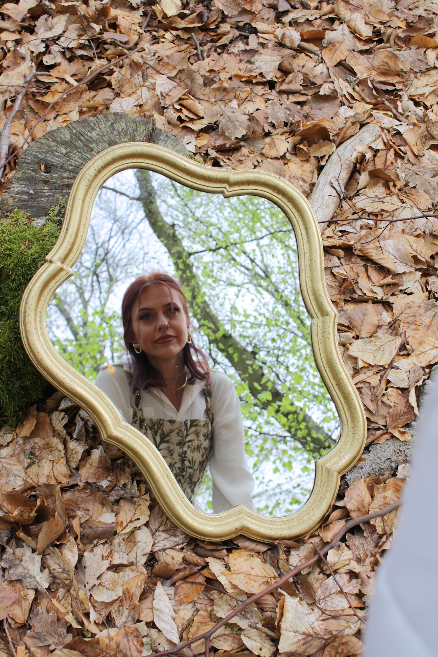 Jess looking into a gold mirror.